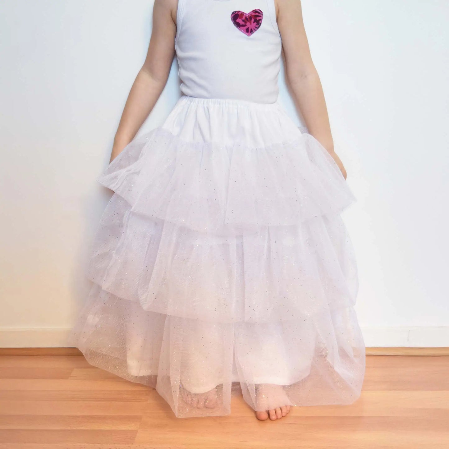 Petite fille debout en jupon blanc à volants de tulle pailleté – patron de couture Kandix