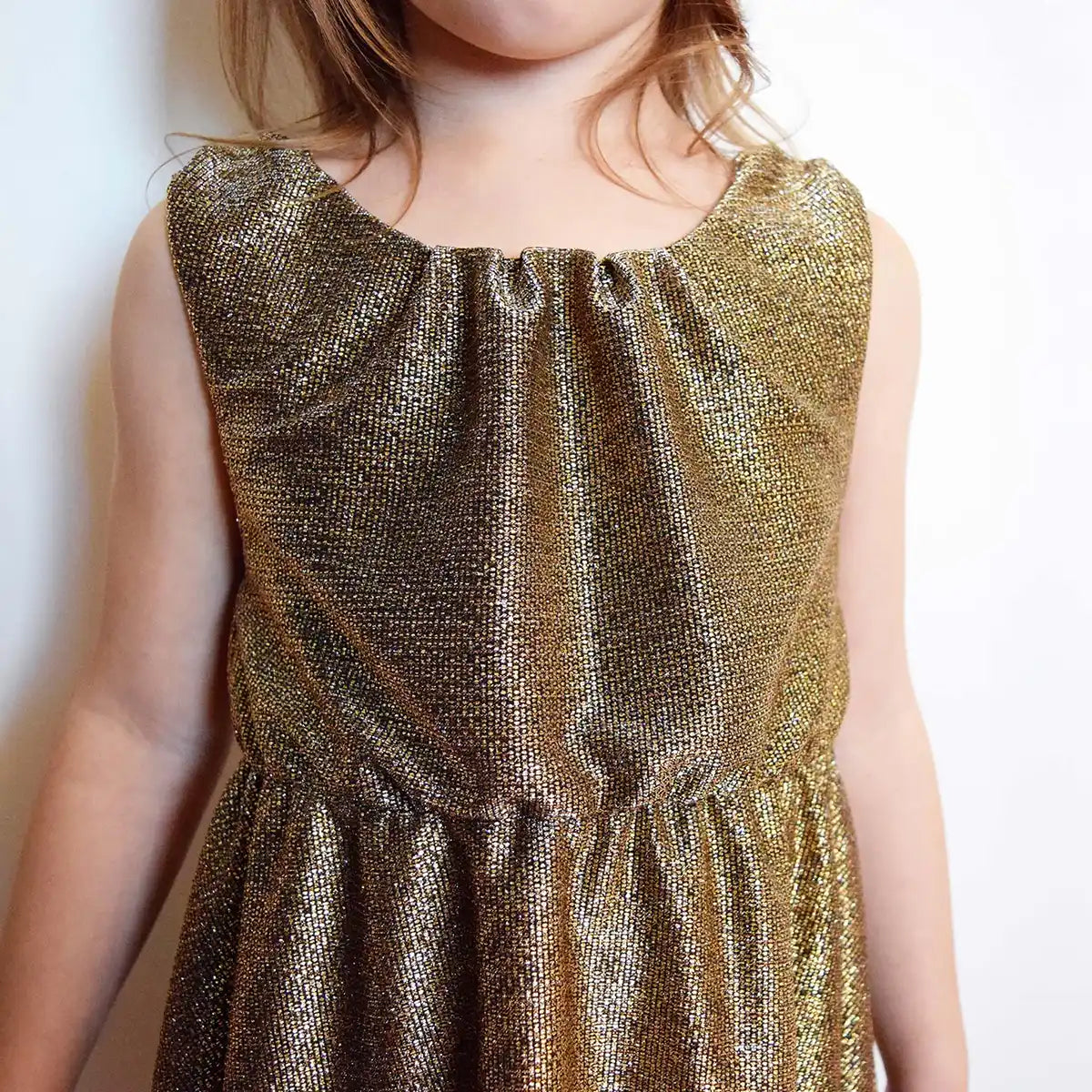 Gros plan sur le buste d’une robe enfant en lurex doré avec encolure froncée – patron de couture Cylia de Kandix