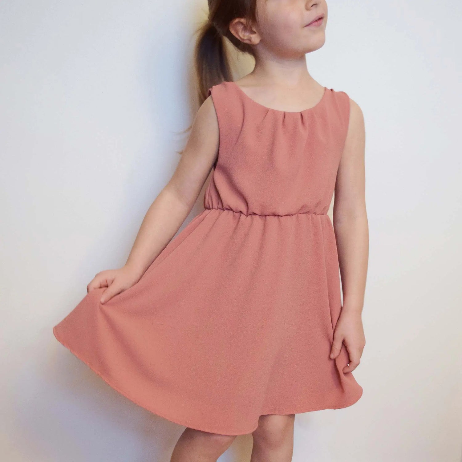 Petite fille en robe rose tenant les pans de la jupe – patron de couture Cylia de Kandix