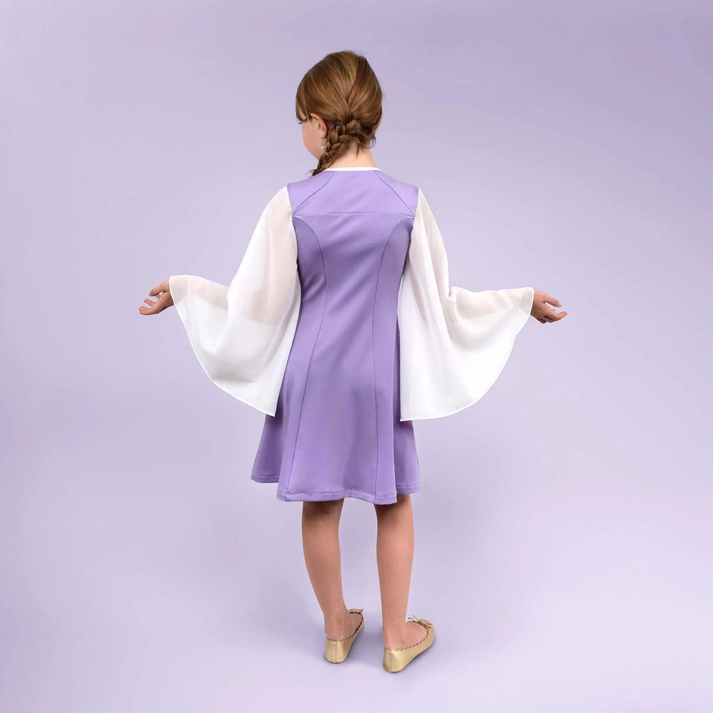 Vue de dos centrée d’une fillette dans une robe lilas, bras écartés pour montrer l’ampleur des manches - patron de couture Gaby de Kandix