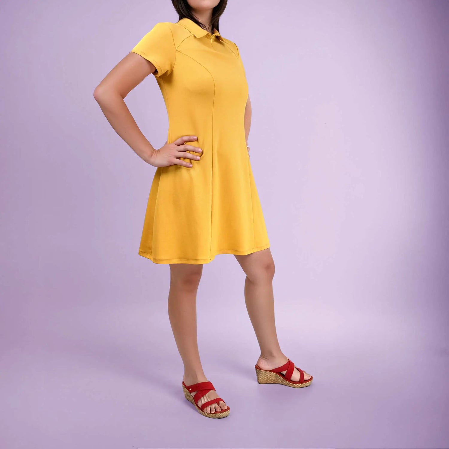 Femme de profil en robe polo jaune avec les mains sur la taille - patron de couture Gaby de Kandix