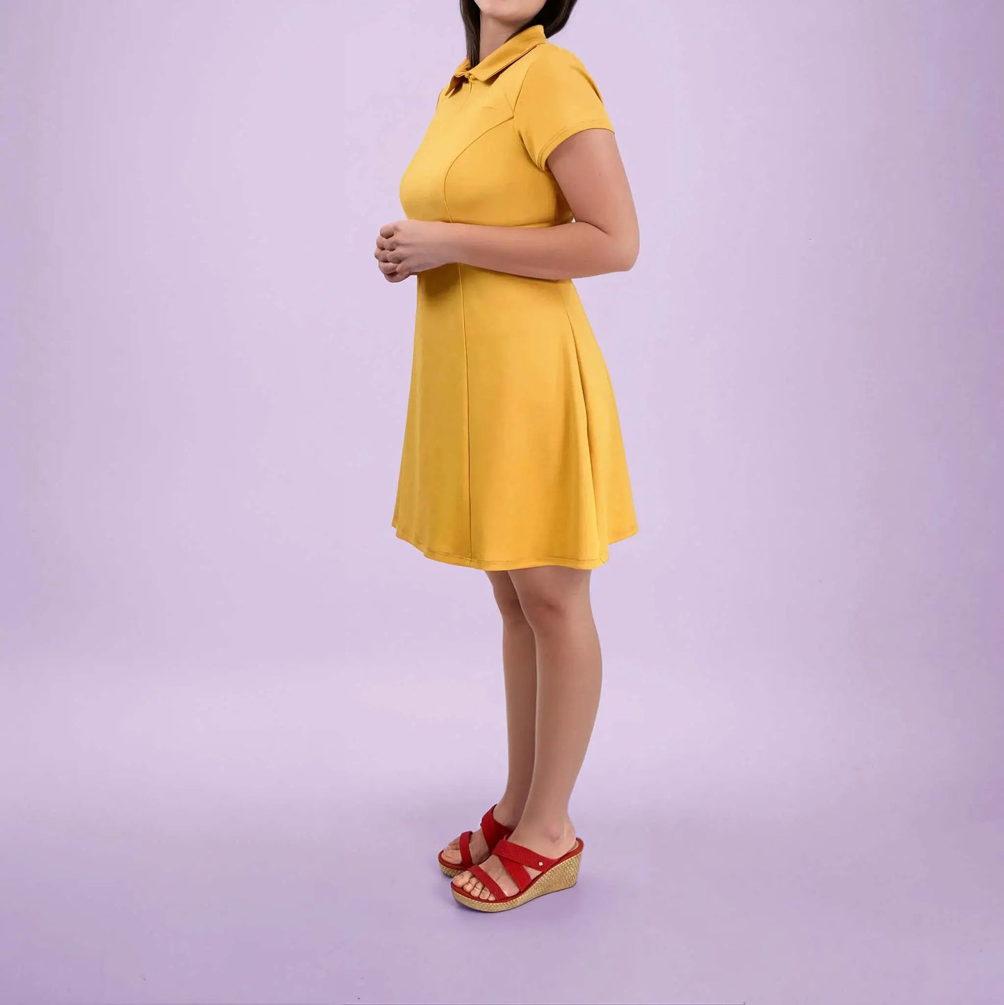 Robe polo jaune vue de côté avec les mains jointes devant - patron de couture Gaby de Kandix