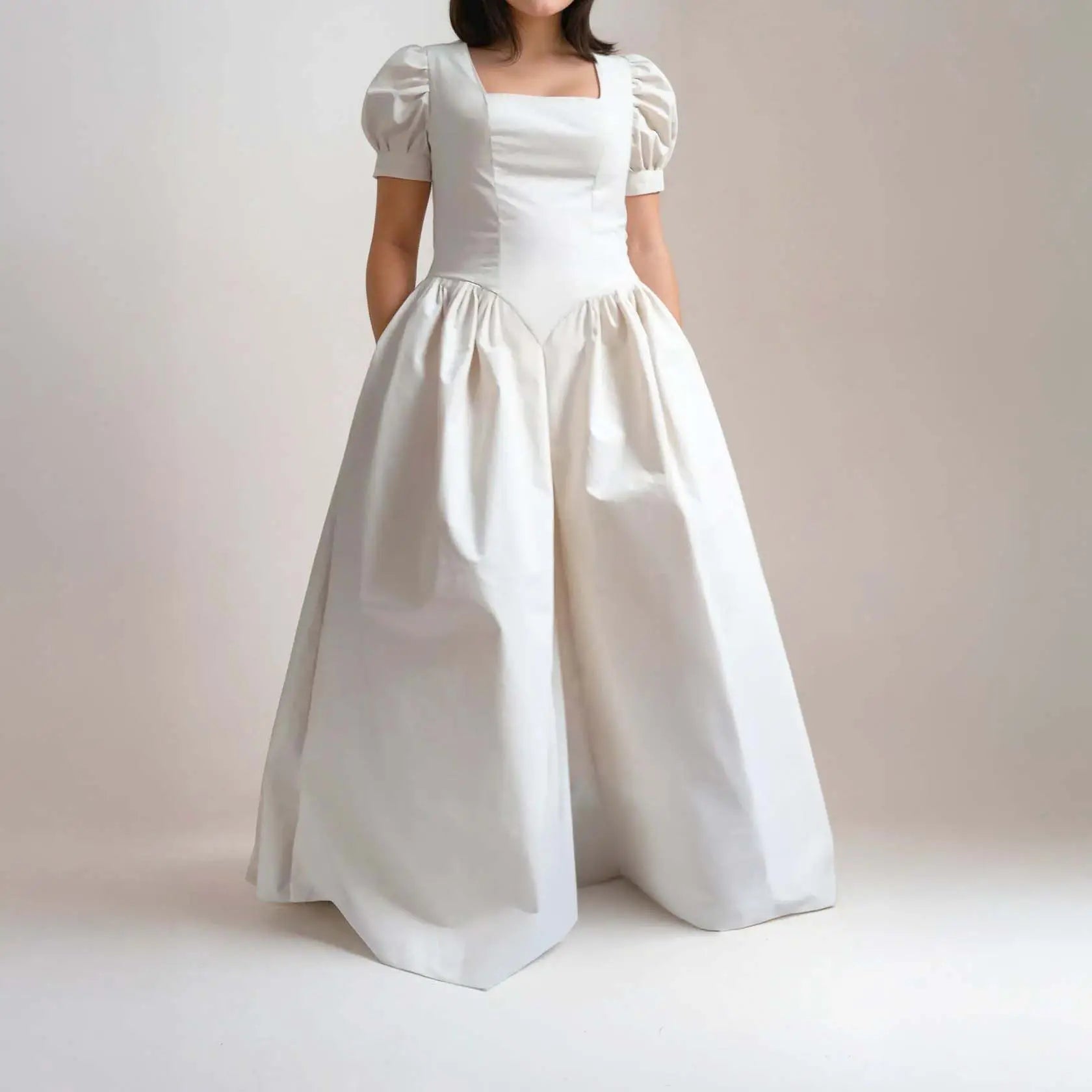 Robe longue princesse écrue avec manches ballon et taille marquée, photographiée sur fond studio – patron de couture Margaux de Kandix