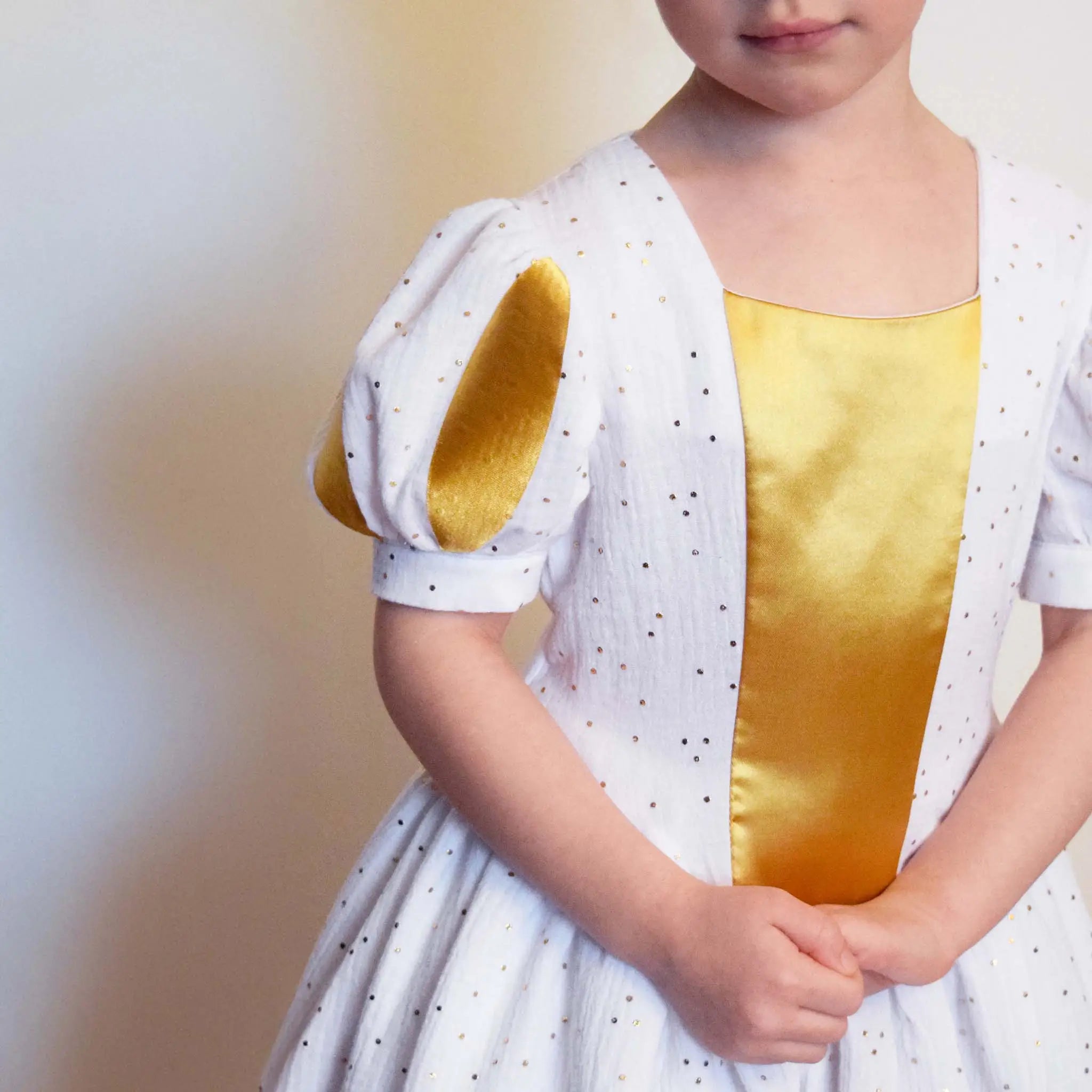 Robe de princesse enfant blanche et dorée avec manches ballons et détails satinés – patron de couture Margaux de Kandix