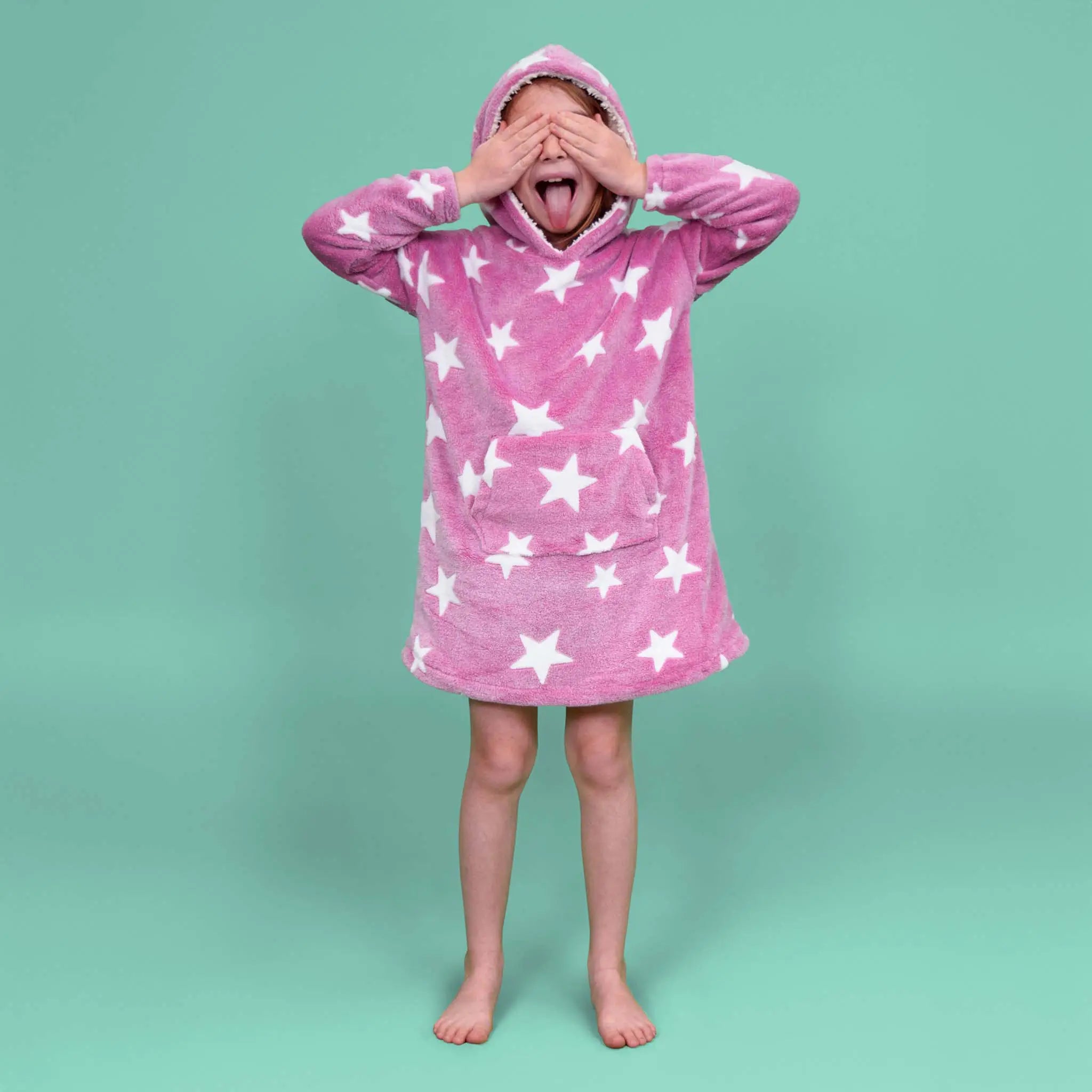 Enfant portant le sweat Casimir rose à étoiles blanches, capuche relevée, yeux fermés et langue tirée - patron de couture Kandix