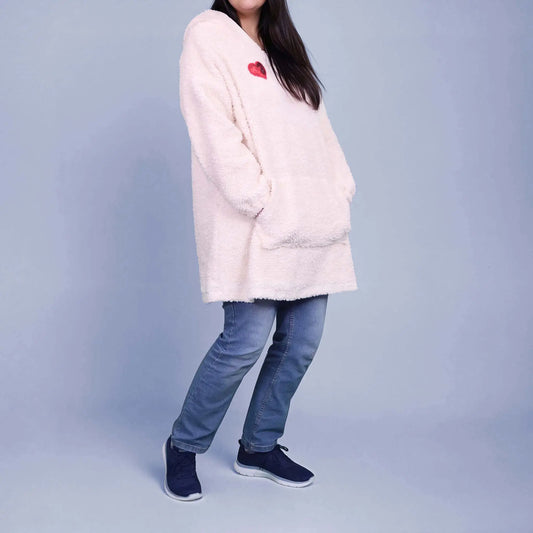 Femme portant un sweat blanc à capuche avec un cœur rouge sur la poitrine, les mains dans la poche devant - patron de couture Casimir de Kandix