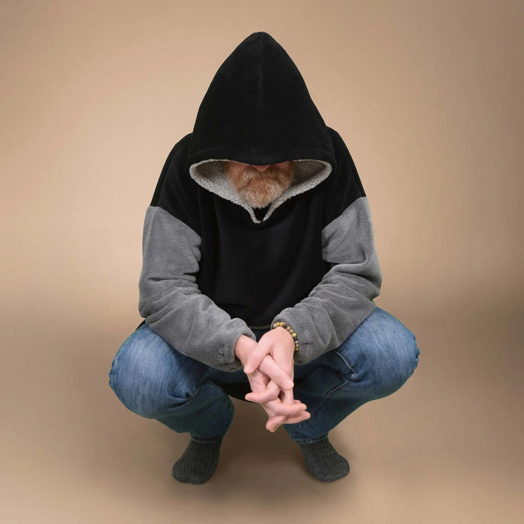 Homme accroupi en sweat Casimir à capuche, visage caché, ambiance décontractée - patron de couture Casimir de Kandix