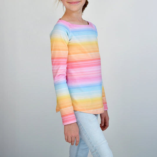 T-shirt raglan enfant vu de profil, col bateau et tissu rayé multicolore pastel façon arc-en-ciel, manches longues – patron de couture TAO de Kandix