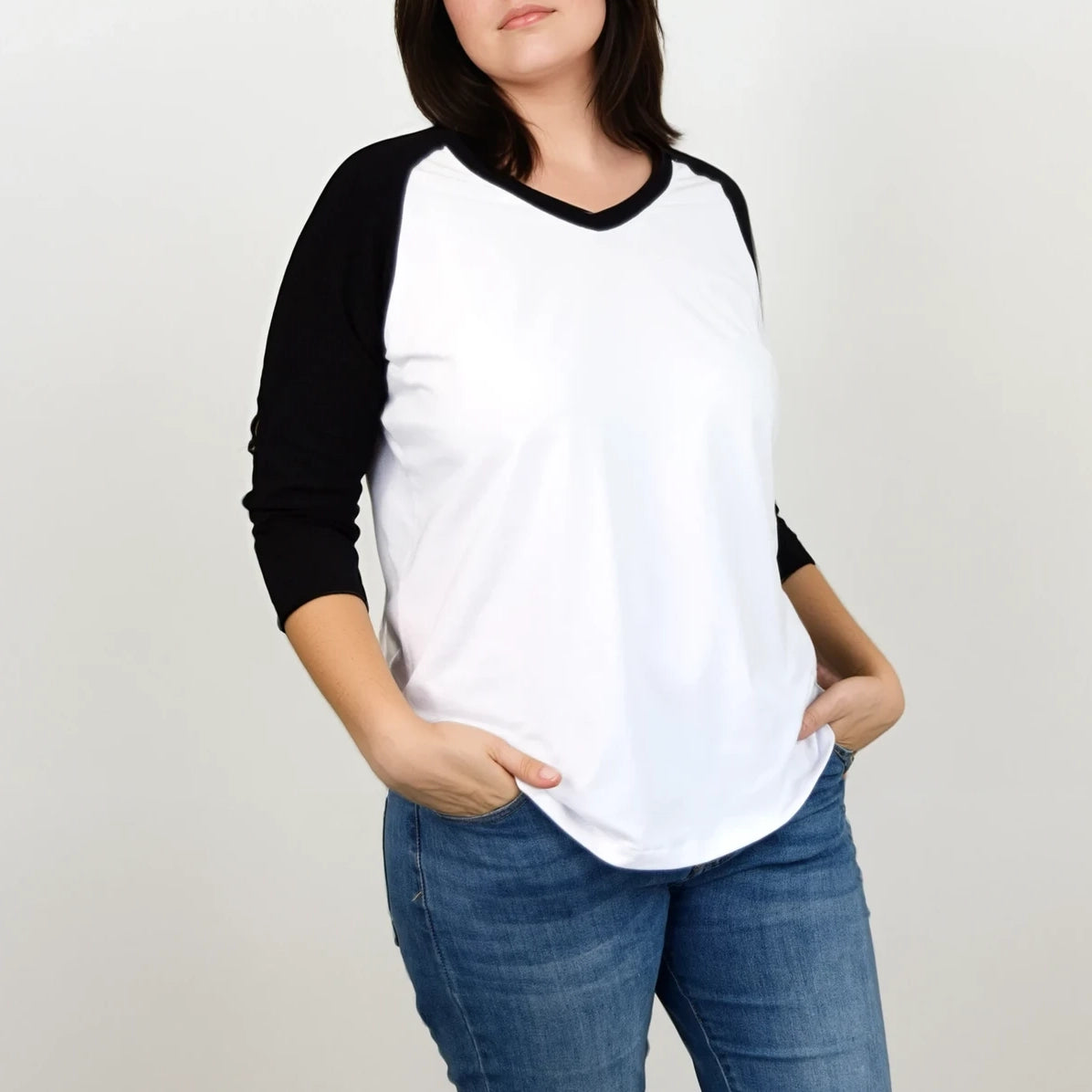 T-shirt raglan femme TAO avec col en V, manches 3/4 noires et buste blanc, mains dans les poches – patron de couture TAO de Kandix