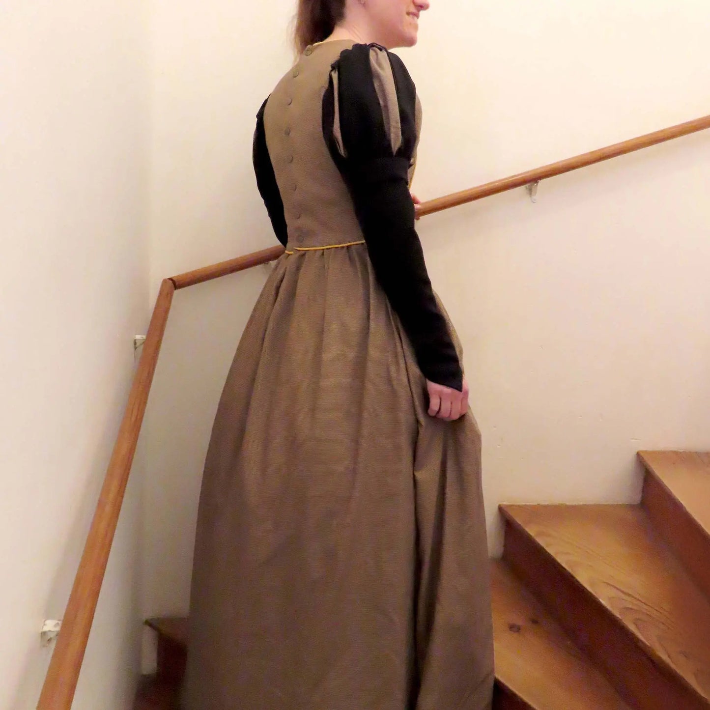Vue arrière d’une robe de princesse dans un escalier, manches longues et jupe volumineuse – patron de couture Margaux de Kandix