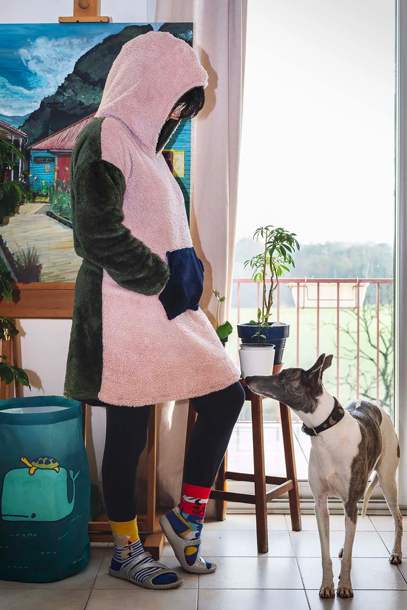 sweat doudou adulte tricolore vu de profil avec capuche, interaction avec un chien près d’un pot de fleur - patron de couture Casimir de Kandix