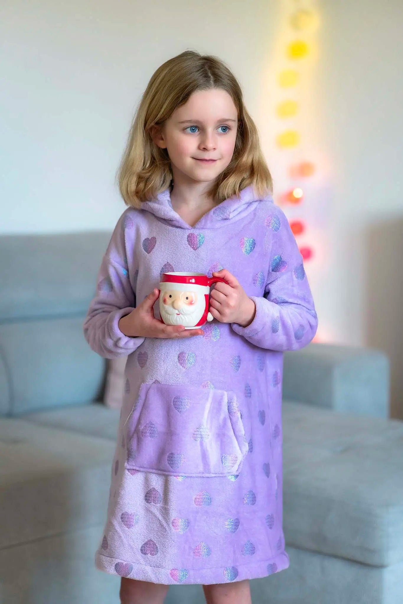 Sweat doudou enfant violet à cœurs irisés, debout avec une tasse père Noël entre les mains, ambiance cocooning - patron de couture Casimir de Kandix