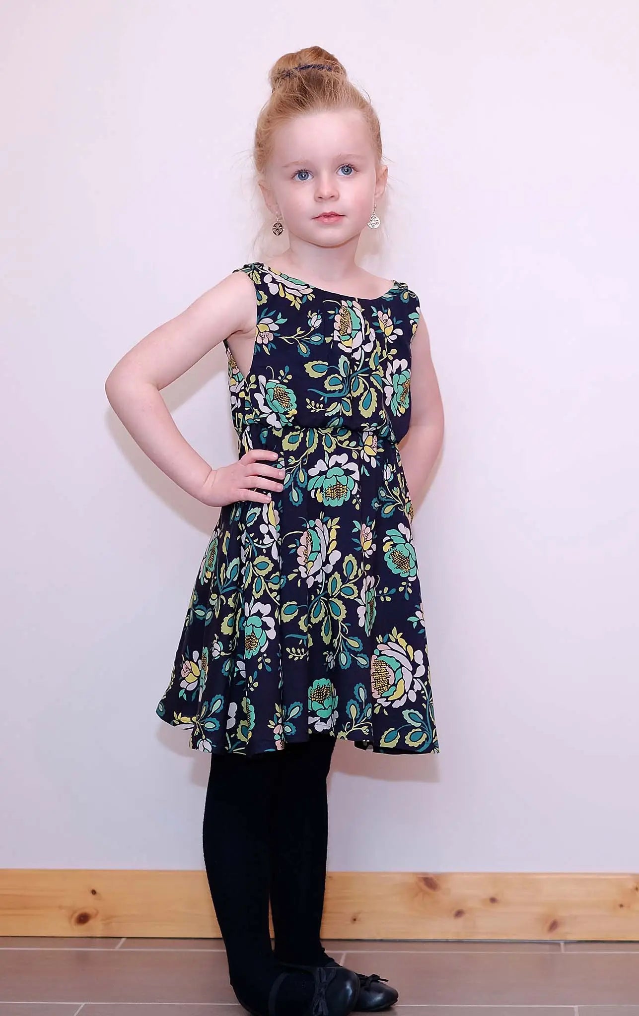 Fillette rousse debout, main sur la taille, en robe bleu marine fleurie – patron de couture Cylia de Kandix