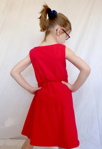 Vue de dos d’une fillette en robe rouge avec les mains sur les hanches – patron de couture Cylia de Kandix