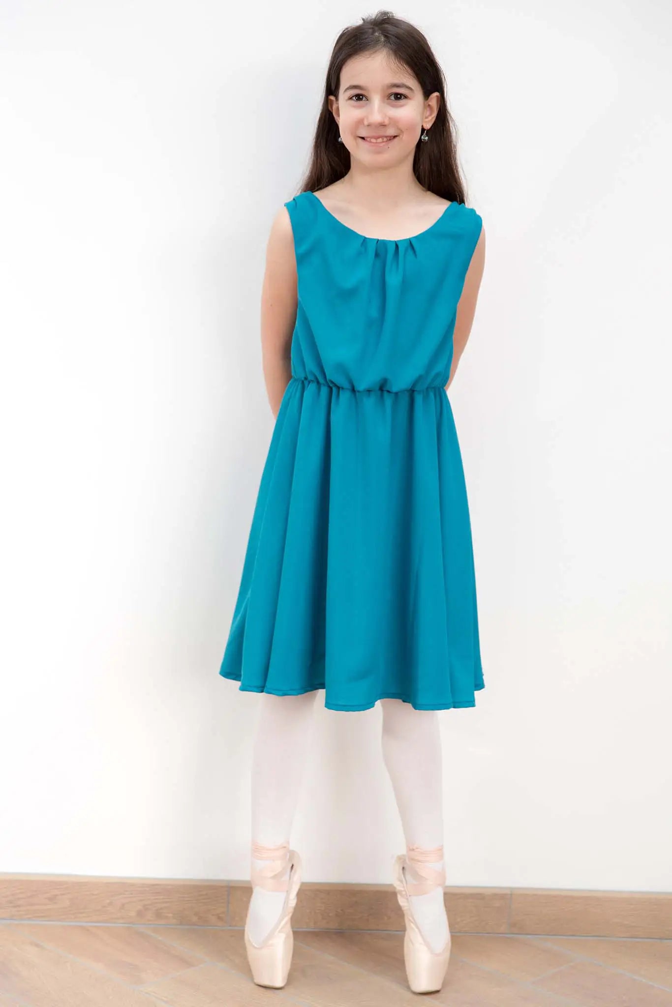 Jeune fille en robe turquoise exécutant une pose de danse classique avec grâce – patron de couture Cylia de Kandix