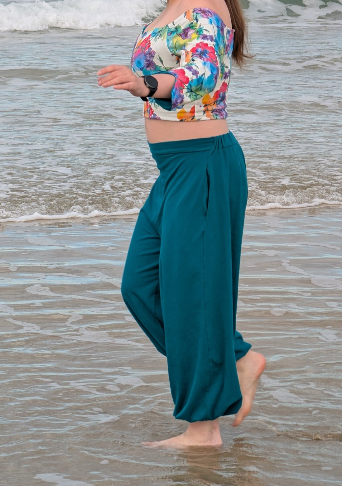 Ensemble Yasmine femme, top fleuri multicolore et pantalon vert canard, porté à la plage, vue de profil – patron Kandix