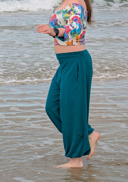 Ensemble Yasmine femme, top fleuri multicolore et pantalon vert canard, porté à la plage, vue de profil – patron Kandix