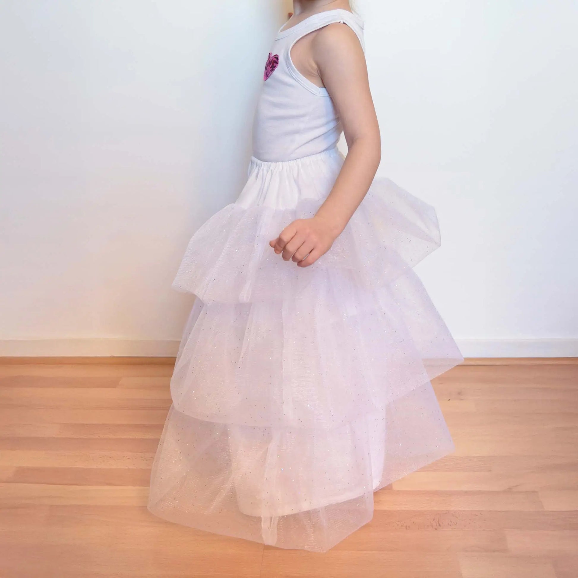 Petite fille en jupon blanc à volants de tulle, vue de profil en train de marcher – patron de couture Kandix