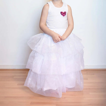 Petite fille debout portant un jupon blanc à volants en tulle pailleté, position statique – patron de couture Kandix