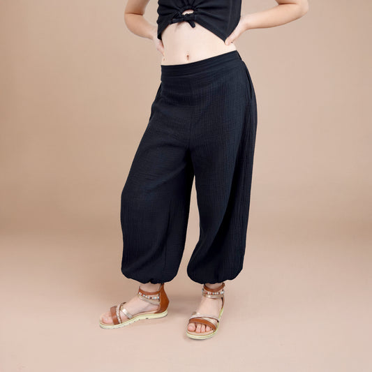 Pantalon Yasmine enfant noir à jambes amples, vue face mains sur hanches – patron Kandix