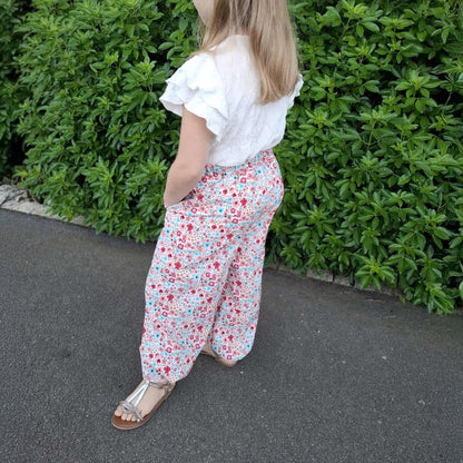 Pantalon Yasmine enfant a motif fleuri rose et vert, vue de dos avec poches – patron Kandix