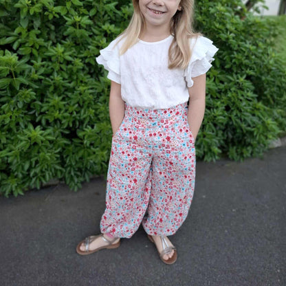 Pantalon Yasmine enfant a motif fleuri rose et vert, jambes amples, vue de face – patron Kandix
