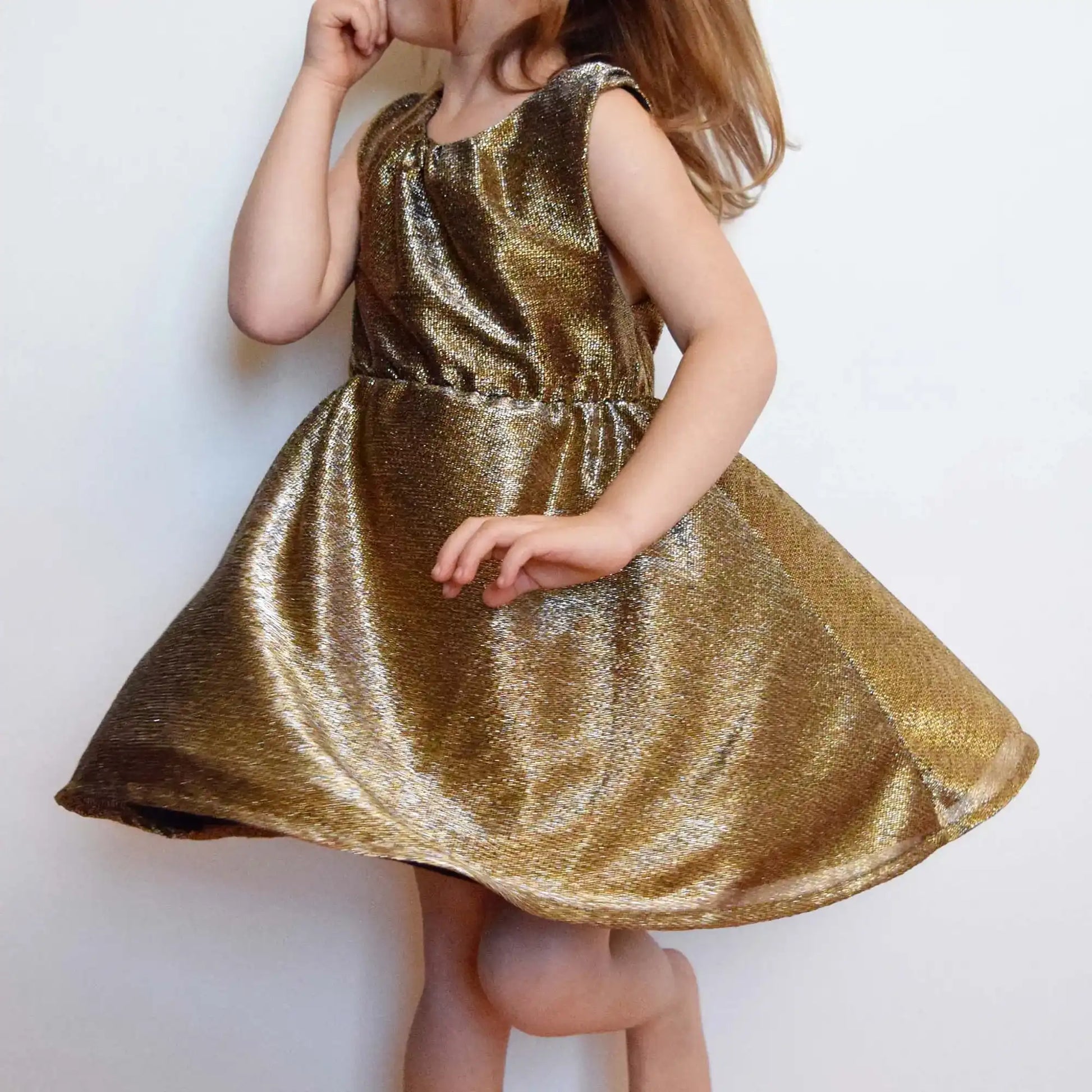 Robe enfant dorée qui tourne, vue de profil avec effet de jupe qui s’envole – patron de couture Cylia de Kandix