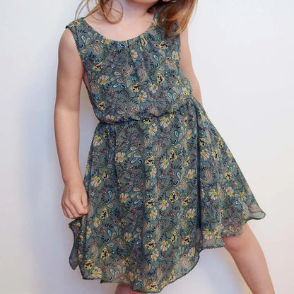 Enfant posant de face en robe Cylia imprimé fleuri, main sur la hanche – patron de couture Cylia de Kandix