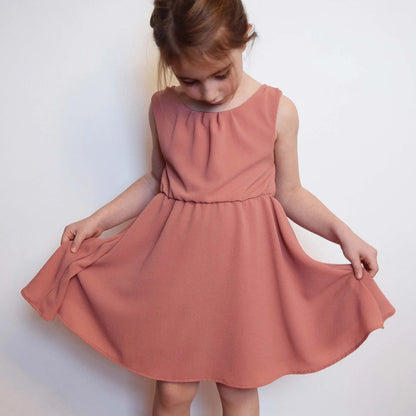 Robe en crêpe rose tenue à deux mains pour montrer l’ampleur de la jupe – patron de couture Cylia de Kandix