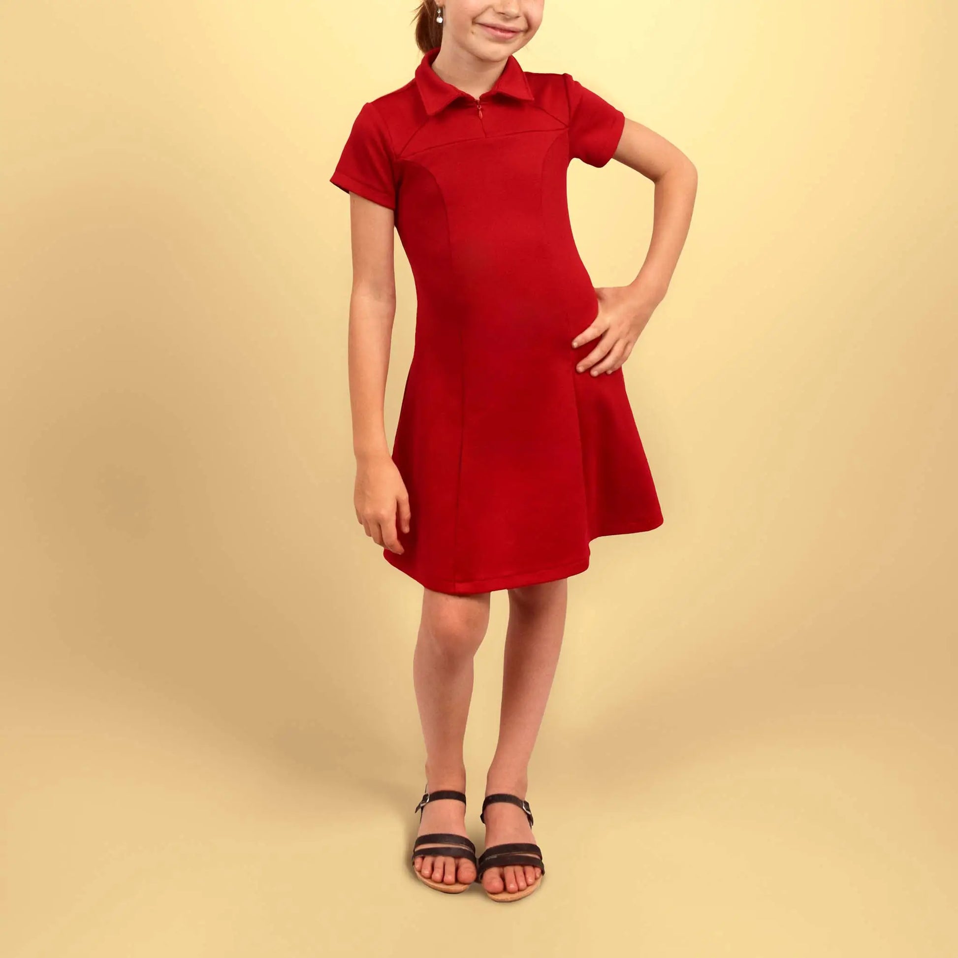 Robe polo rouge pour enfant vue de face avec une main posée sur la hanche - patron de couture Gaby de Kandix