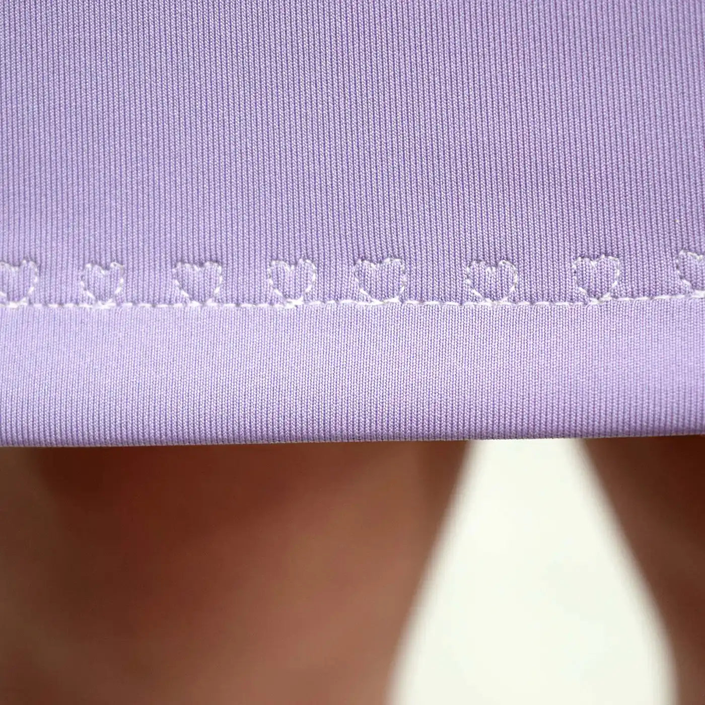 Gros plan sur l’ourlet de la robe lilas avec surpiqûre décorative en forme de petits cœurs blancs - patron de couture Gaby de Kandix