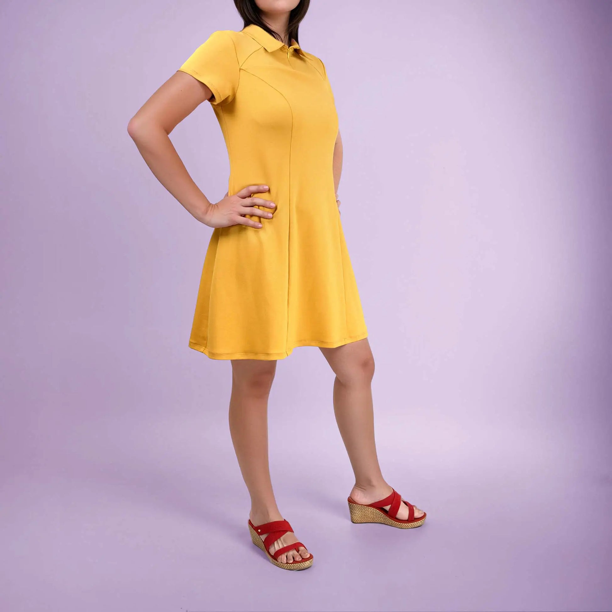Femme de profil en robe polo jaune avec les mains sur la taille - patron de couture Gaby de Kandix