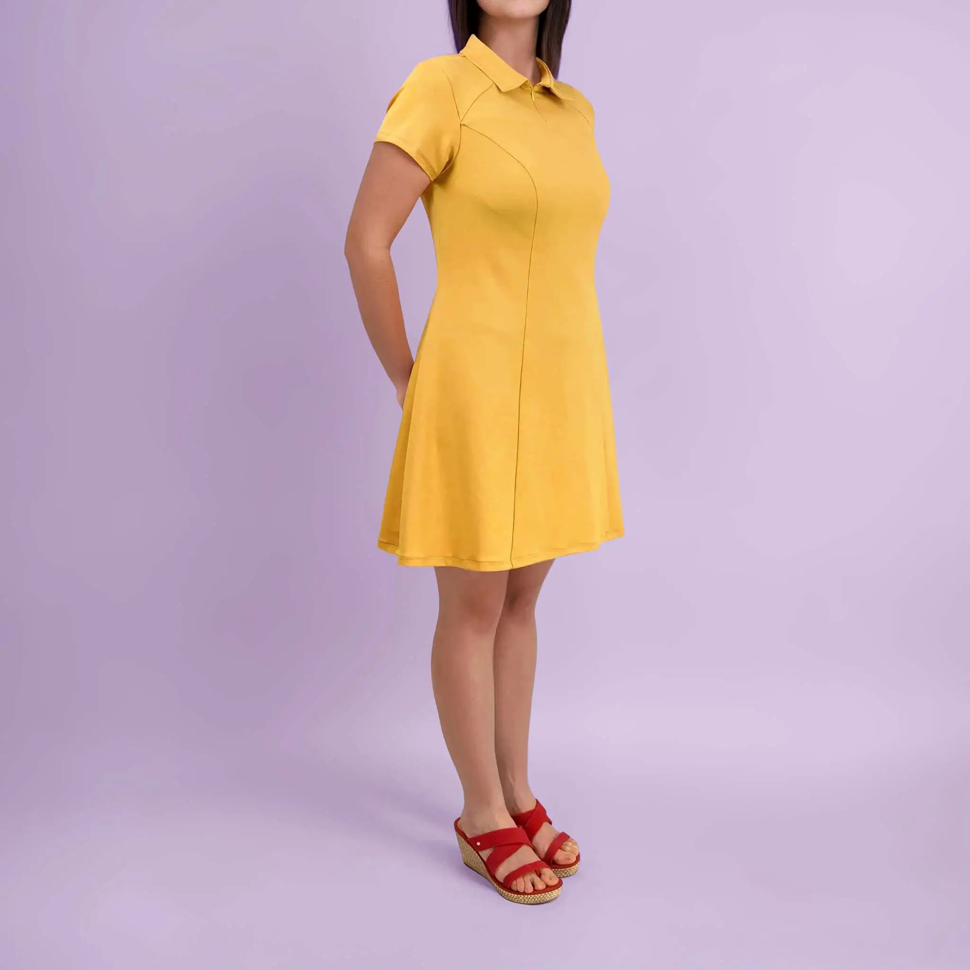 Vue de profil de la robe jaune avec les mains croisées dans le dos - patron de couture Gaby de Kandix