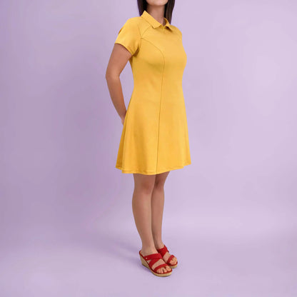 Vue de profil de la robe jaune avec les mains croisées dans le dos - patron de couture Gaby de Kandix