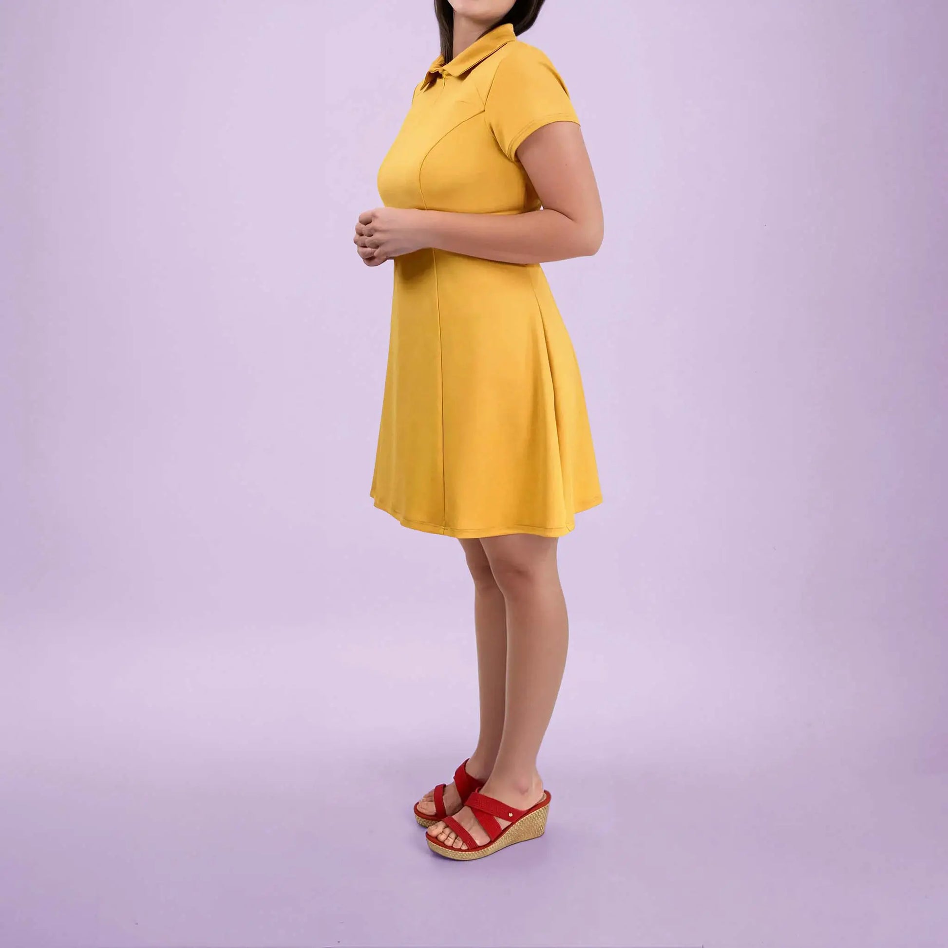 Robe polo jaune vue de côté avec les mains jointes devant - patron de couture Gaby de Kandix