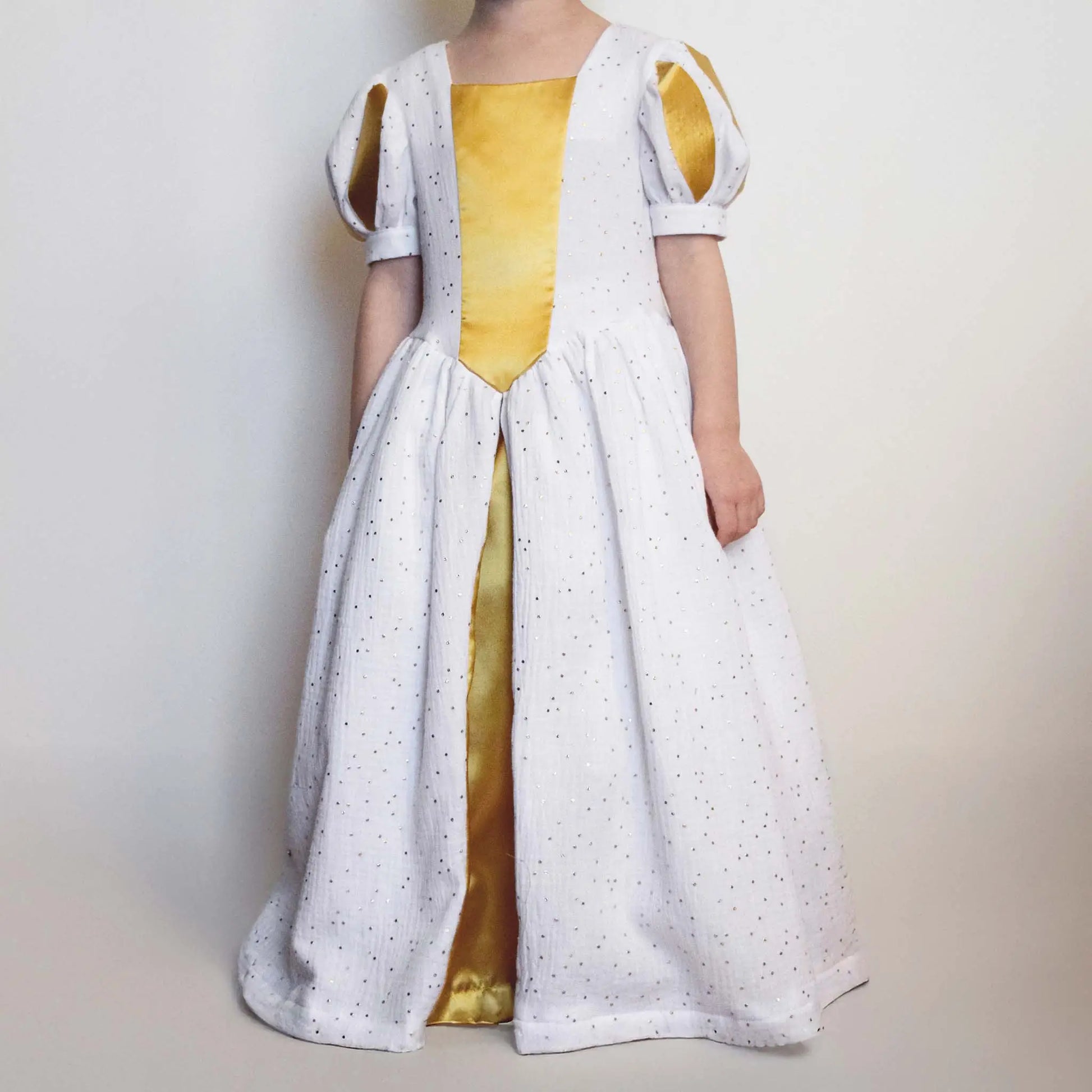 Vue de face de la robe de princesse enfant blanche et dorée en double gaze et satin – patron de couture Margaux de Kandix
