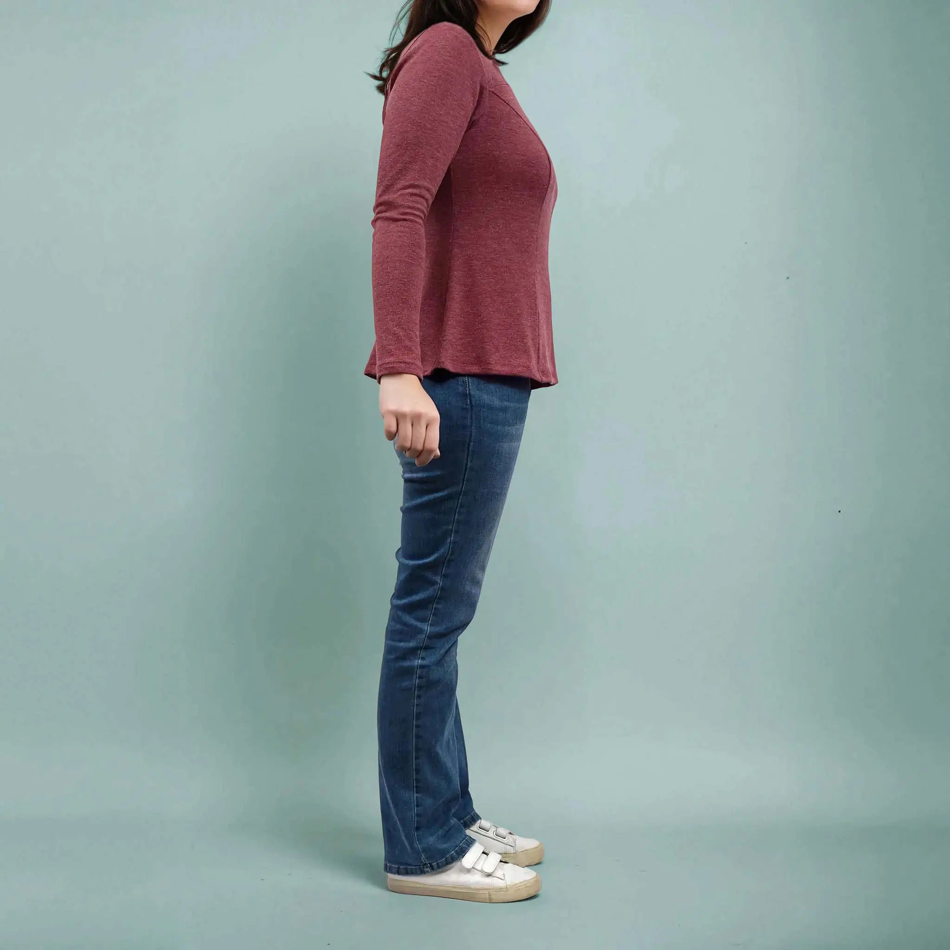 Femme de profil portant un top bordeaux manches longues et un jean – patron de couture Gaby de Kandix