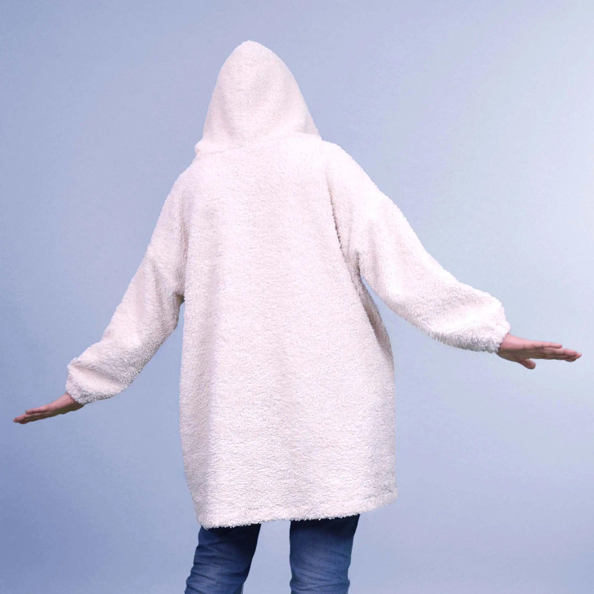 Vue de dos d'une femme en sweat à capuche, bras écartés et capuche relevée - patron de couture Casimir de Kandix