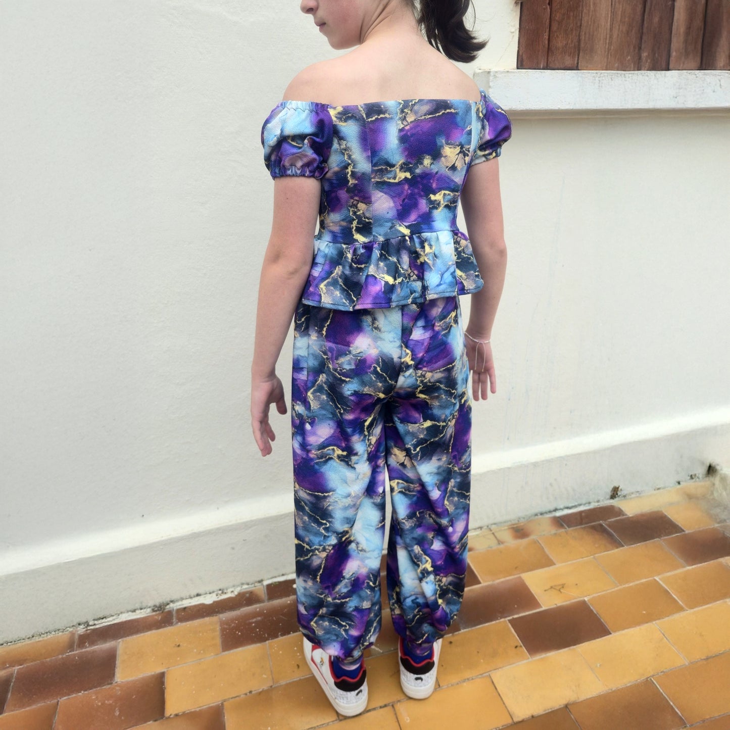 Top Yasmine enfant imprimé marbré bleu et violet avec manches courtes bouffantes, porté avec pantalon assorti, vue de dos – patron Kandix