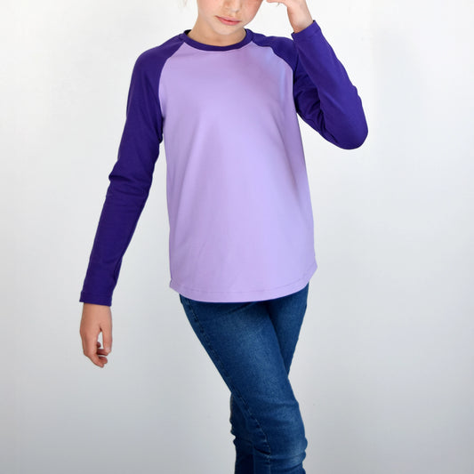 T-shirt raglan enfant manches longues en jersey lilas et violet, vu de face dans une pose décontractée – patron de couture TAO de Kandix